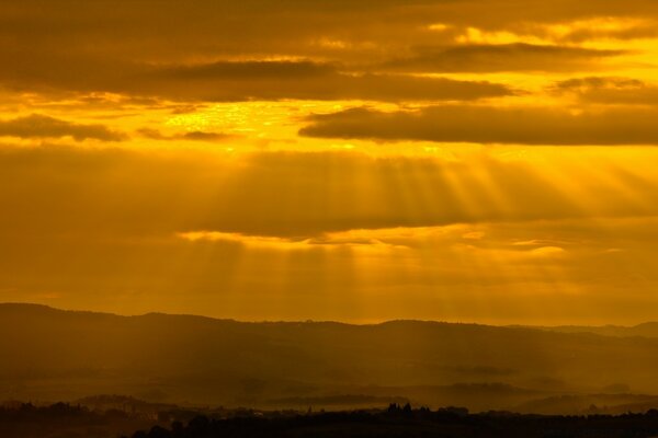 Os raios do sol atravessam as espessas nuvens