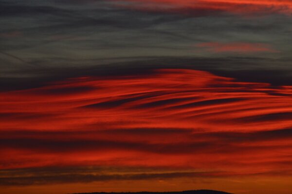 Rot-grauer Sonnenuntergang in den Wolken