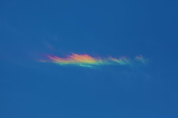 Eine einsame Wolke schimmert in den Farben des Regenbogens