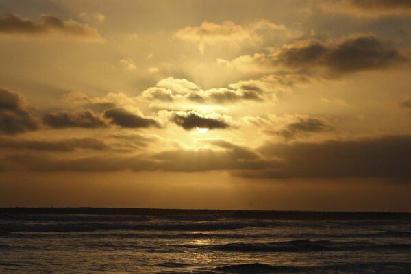 Le calme de la mer et le soleil caché derrière les nuages