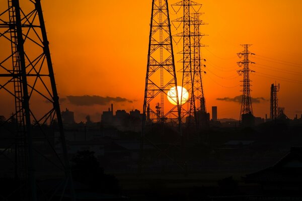 Electric towers on the background of the setting sun