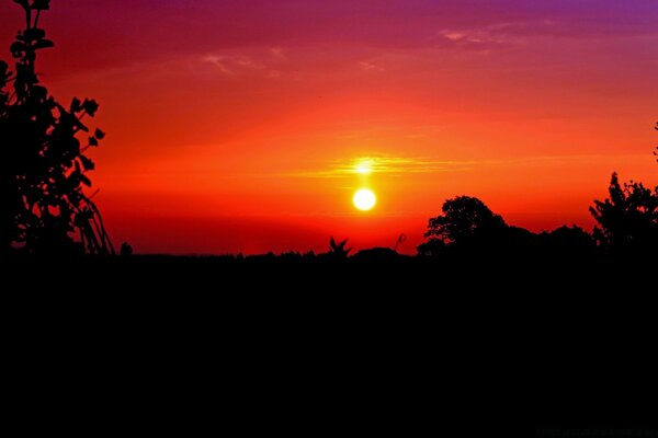 Puesta de sol en el fondo de un cielo naranja ardiente