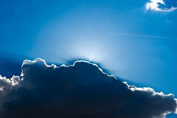 Soleil derrière un nuage dans un ciel bleu