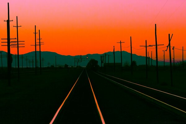 Road and pillars on the background of the sunset sky