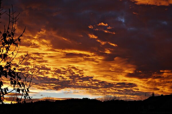 Puesta de sol a través de las nubes en el cielo de la tarde