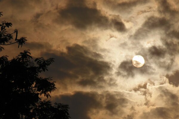 A small sun behind dark clouds