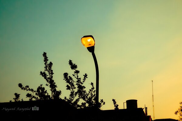 A burning lantern on the background of sunset