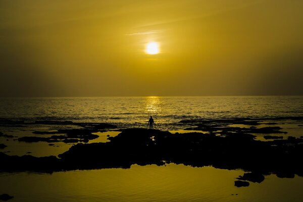 Homme au bord de l eau en regardant le coucher du soleil