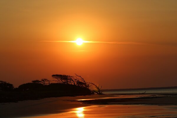 Bright orange sky with a beautiful sunset reflected in the water