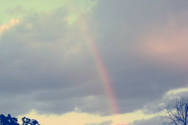 Rainbow on the background of an autumn cloudy sky