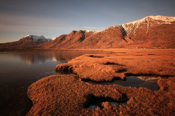 Lake and desert on sunset background