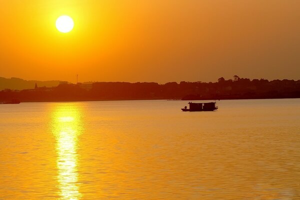 Un barco navega a lo largo de la ciudad al atardecer