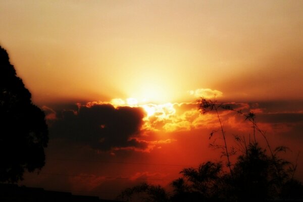 Fiery sunset behind fluffy clouds