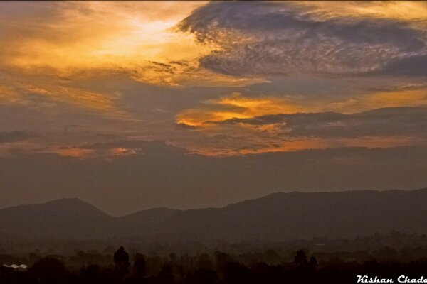 Paisagem com céu cintilante e montanhas ao pôr do sol