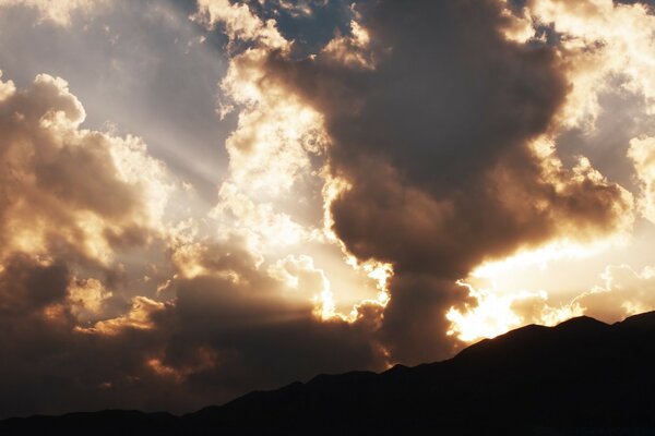 The last rays of the setting sun in the clouds