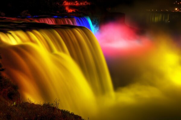 Niedriger Wasserfall mit verschiedenen Farben beleuchtet