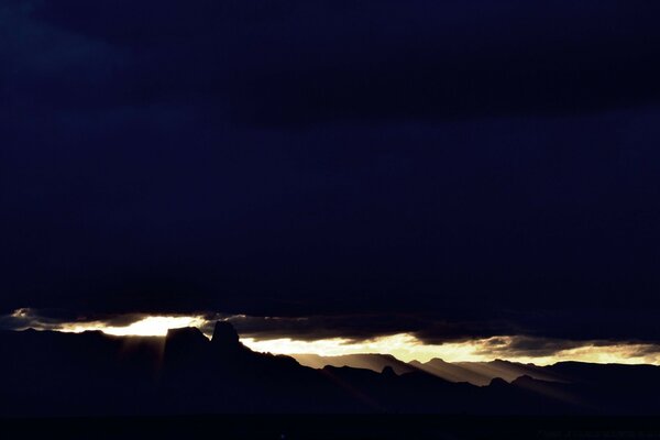 A sky gap with sunlight between black clouds during a storm