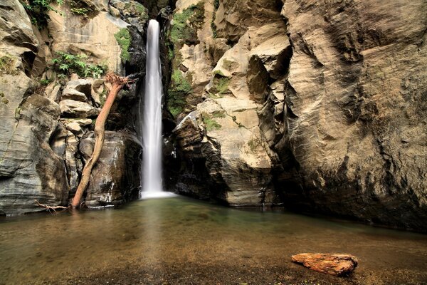 Das Bild eines schönen Wasserfalls, der von einer Klippe bricht