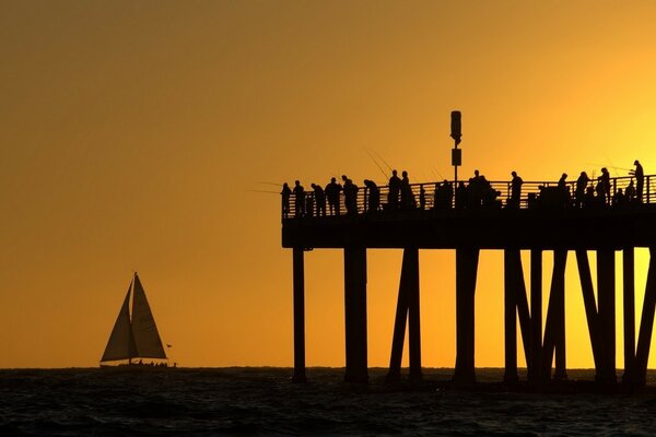 Sonnenuntergang am Meer. Weißes Segel