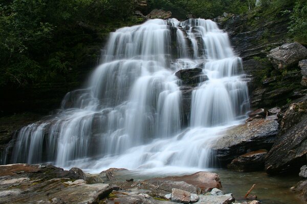 Starker Wasserfall auf Steinen am Fluss