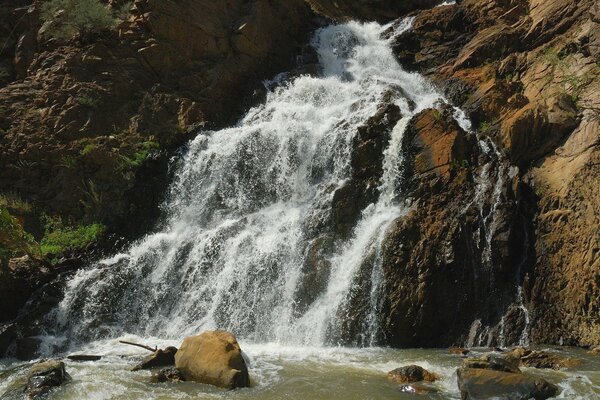 Cascata vicino a una collina rocciosa