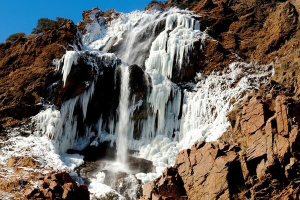 Un fuerte y tormentoso cascada desciende por la roca