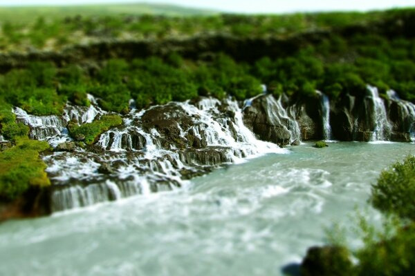 The stream of the waterfall descends into the river