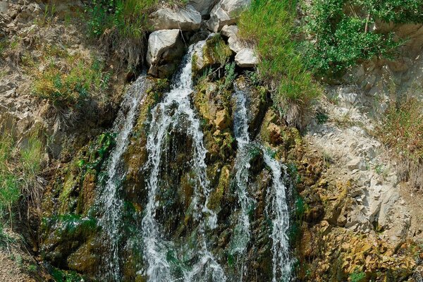 चट्टानों के पास एक झरने के साथ सुंदर परिदृश्य