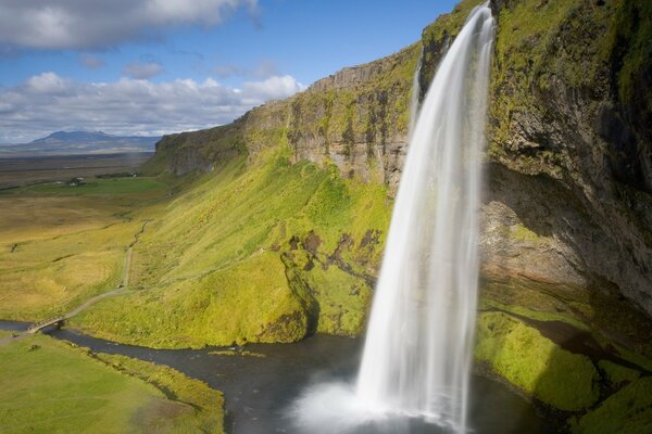 Der Fluss, der vor dem Hintergrund der Steppe in einen Wasserfall übergeht