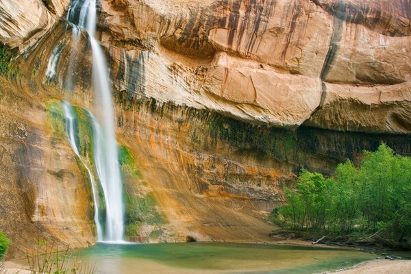 Der Wasserfall fließt vom Felsen in den See