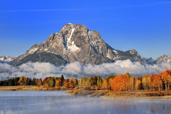 High mountain on the background of lake and forest