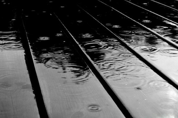 Gouttes de pluie dans la rue sur le bois