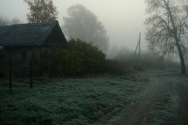 Foggy road with an old house