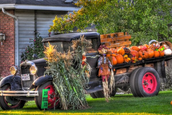 Ein Retro-Auto, das zu Halloween mit Puppen, Glöckchen und Kürbissen geschmückt ist