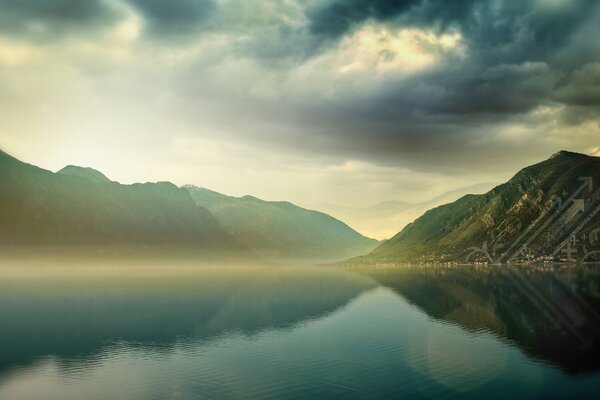 Fog over the water. Mountains and sky