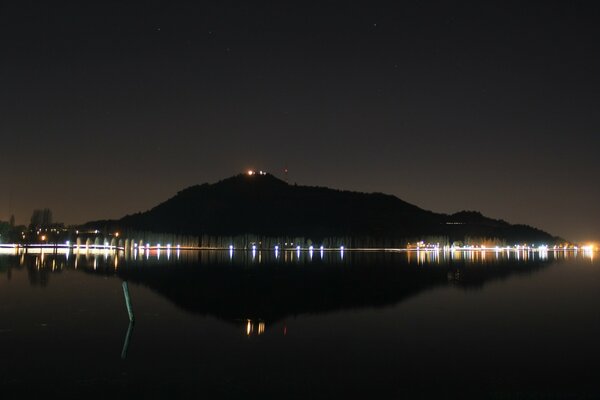 Lago nocturno. Luces de la ciudad nocturna