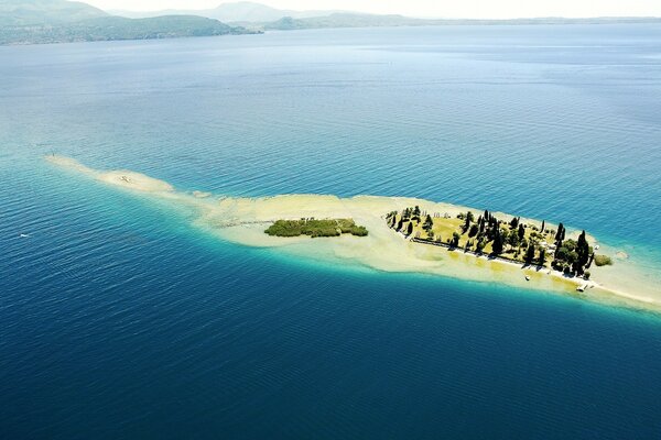 An uninhabited island with a beach in the middle of the ocean