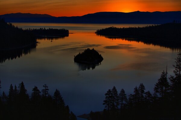 Coucher de soleil orange dans la forêt au bord du lac