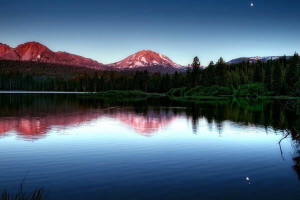 Forest mountains sunset in the reflection of water