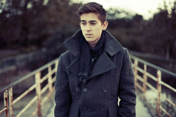 Portrait of a man in a coat. Walking through the autumn park