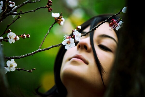 Ragazza inala il profumo dei fiori che sbocciano sull albero