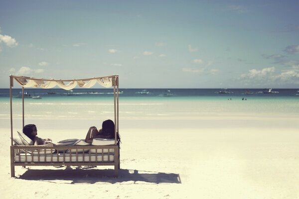 Two girls sunbathing on the beach