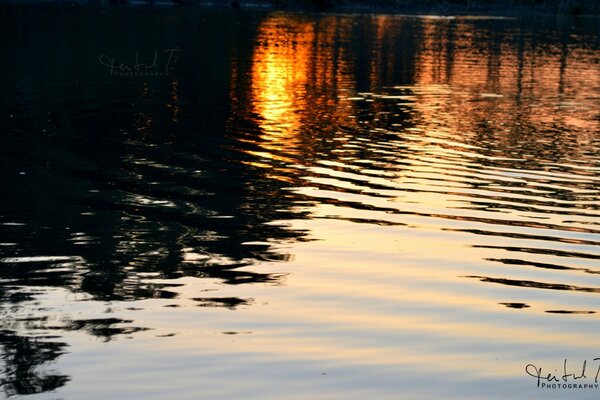 Reflection of the sun s rays during sunset in the lake