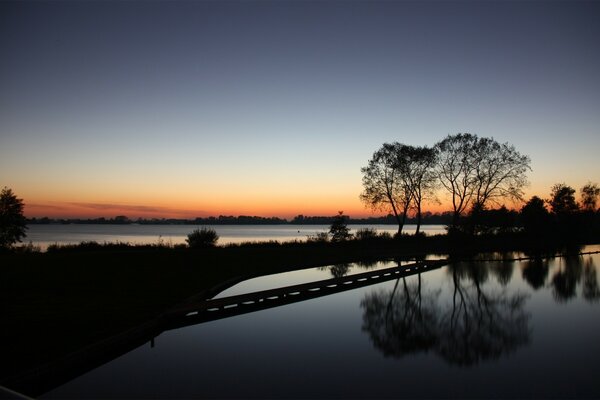 Dämmerung und Sonnenuntergang spiegeln sich im See wider