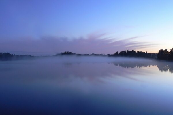 蓝色的夕阳在湖面上。 水边的黄昏