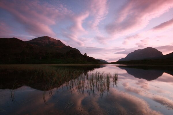 Puesta de sol rosa. Nubes Rosadas sobre el lago. Montaña. Crepúsculo