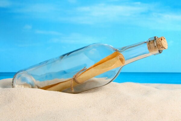 A bottle with a letter lying on the sand