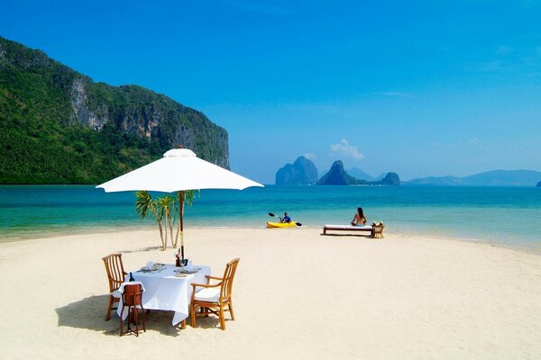 Table on the ocean shore under an umbrella