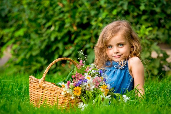 Mädchen im Park mit einem Korb voller Blumen