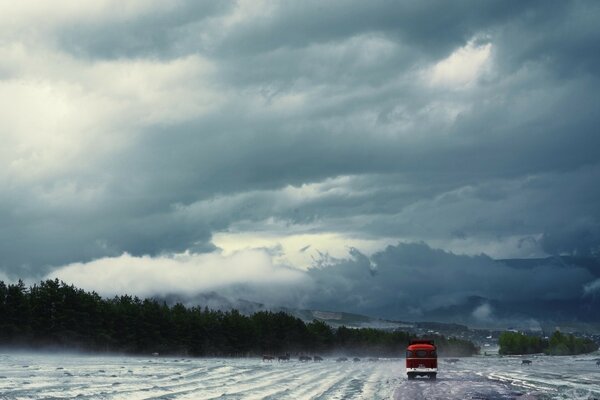 Auto rossa sulla strada innevata